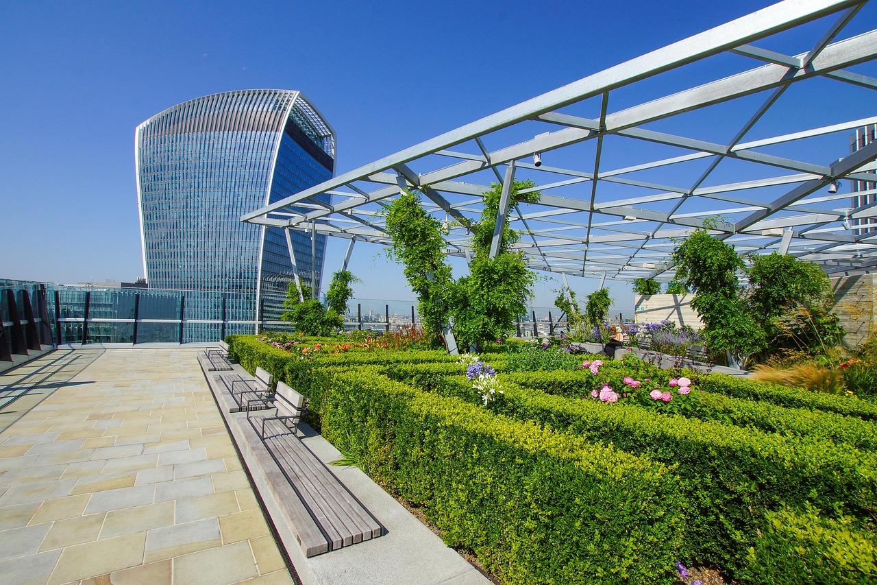A modern building with a vibrant roof garden, highlighting various plants and flowers flourishing on its rooftop